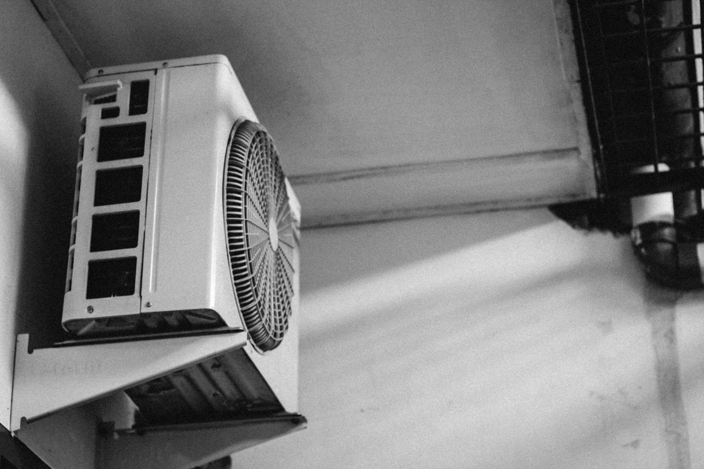Outdoor air conditioning unit mounted beneath a roof.