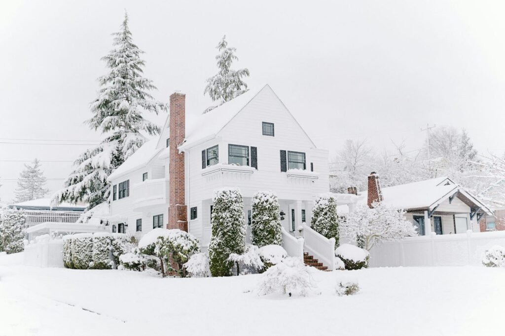 White house and evergreen trees covered in fresh winter snow