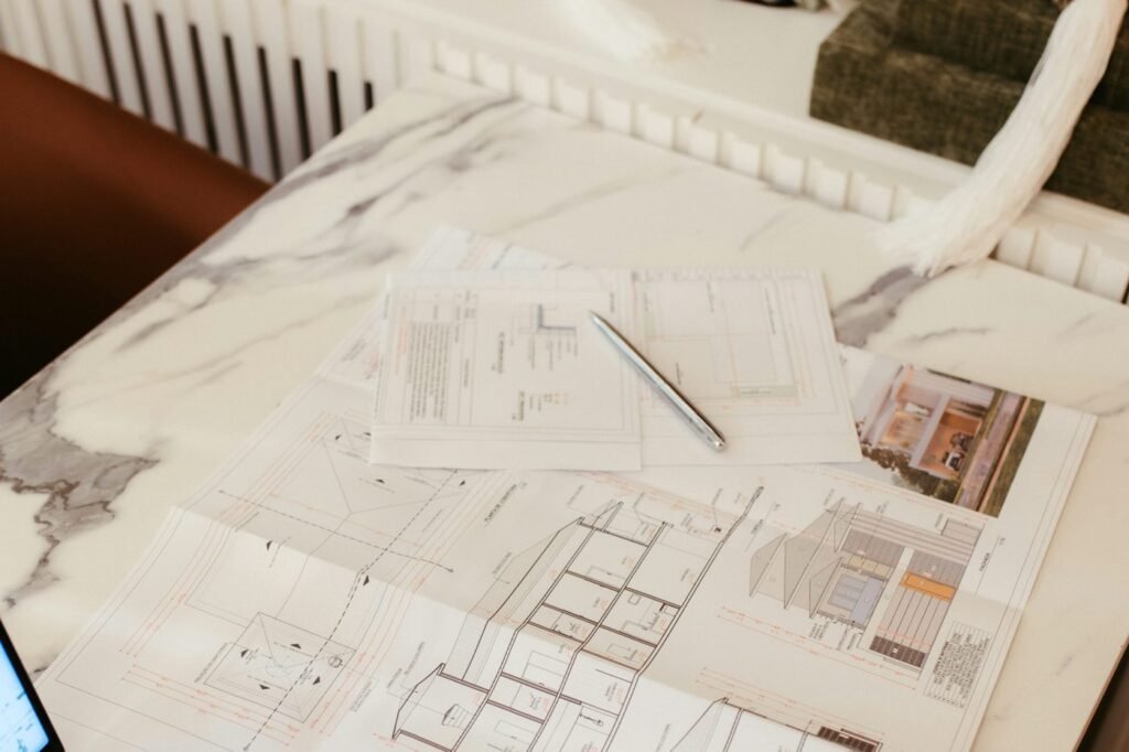 Home floor plans and notes spread across a desk.