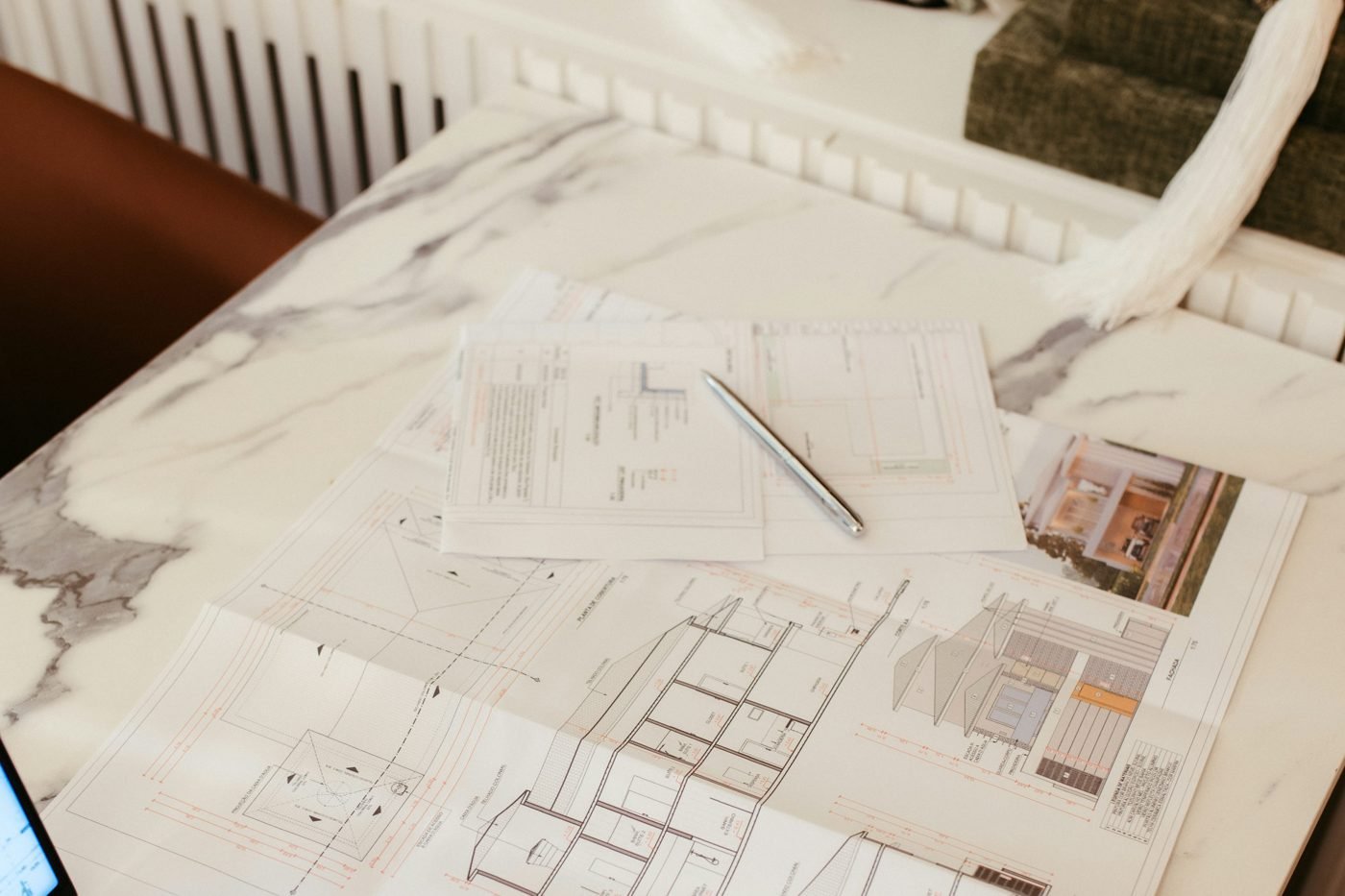 Home floor plans and notes spread across a desk.