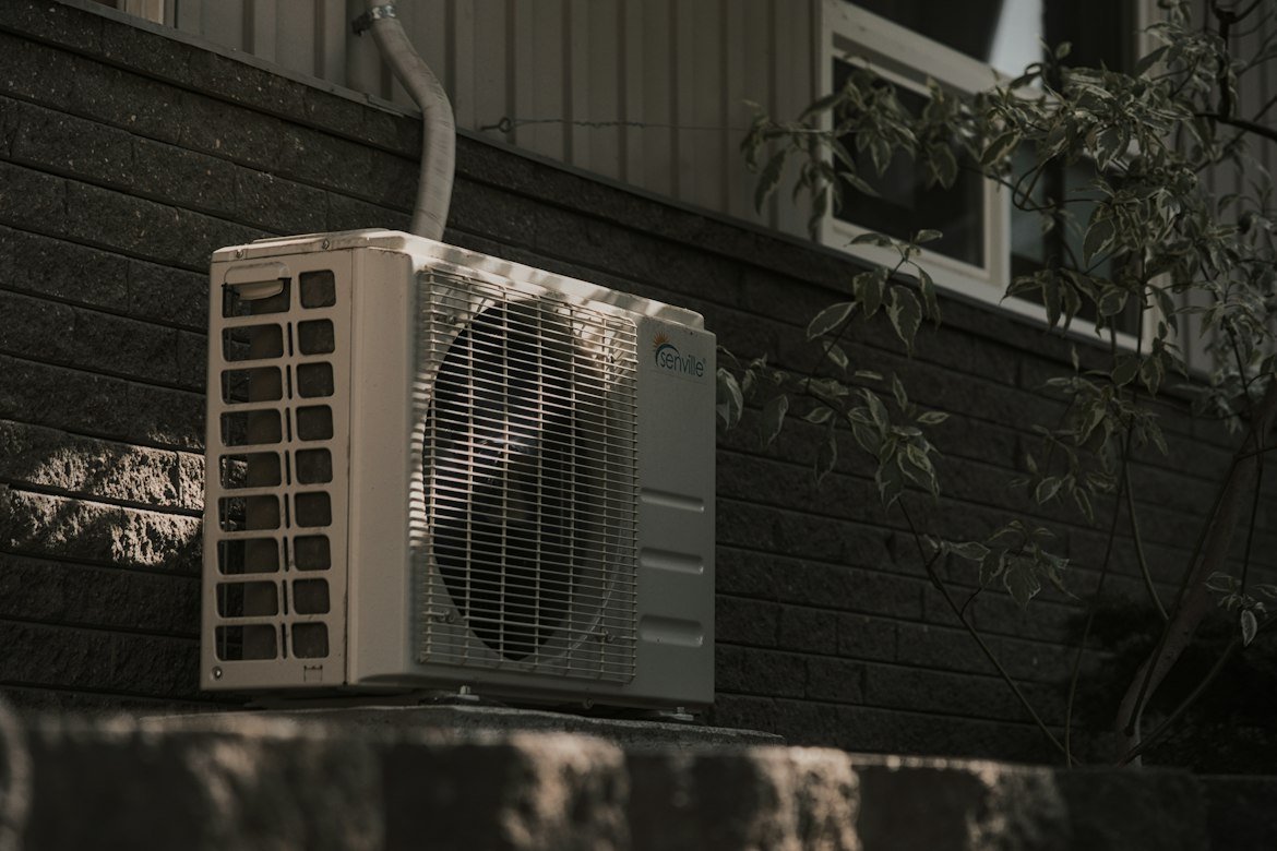 Outdoor air conditioning unit installed beside a house.