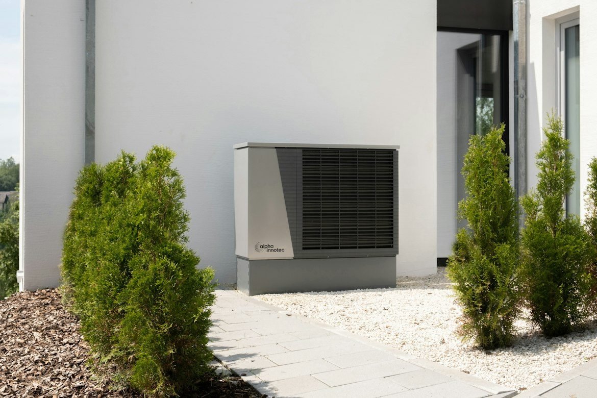 Outdoor heat pump installed beside a modern home.