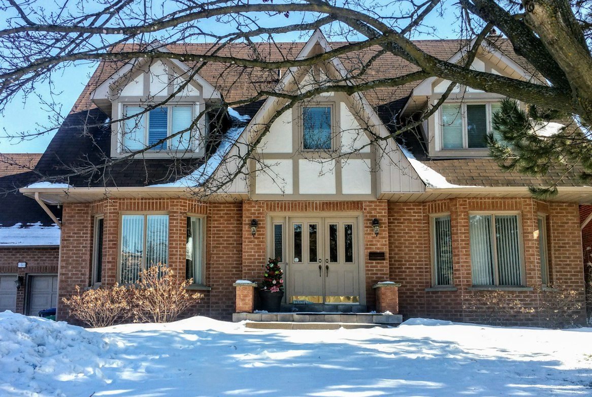 Snow-covered brick home in Brampton during winter.