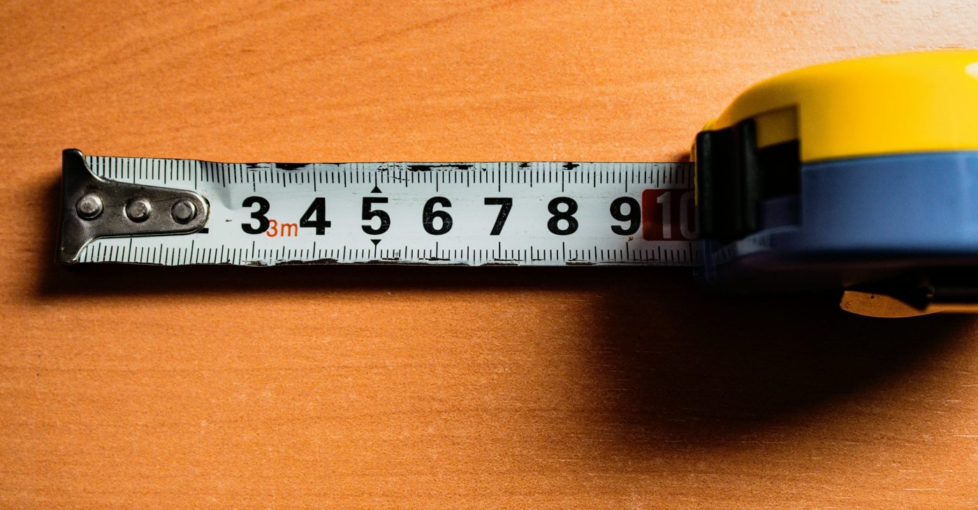 Extended tape measure with centimetre markings on a wooden surface
