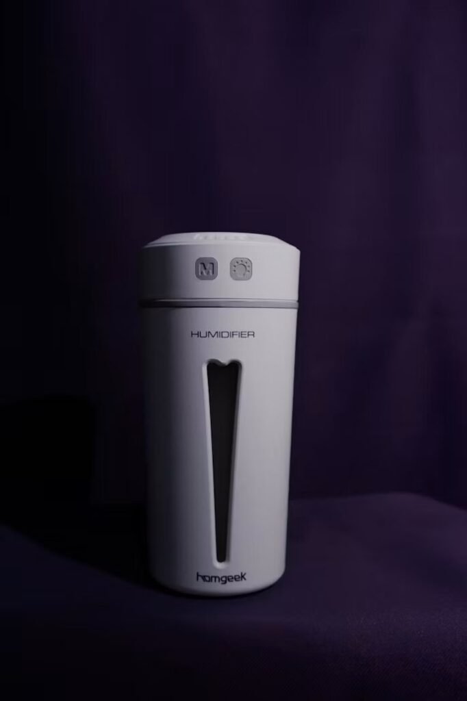 White portable humidifier on a dark surface.