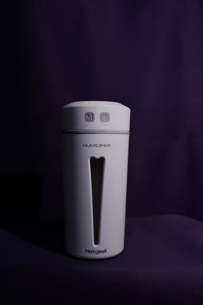 White portable humidifier on a dark surface.