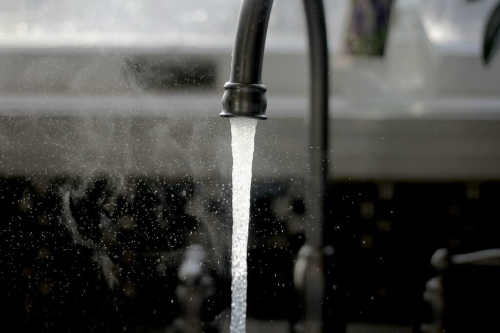 Water running from a kitchen faucet into a sink.
