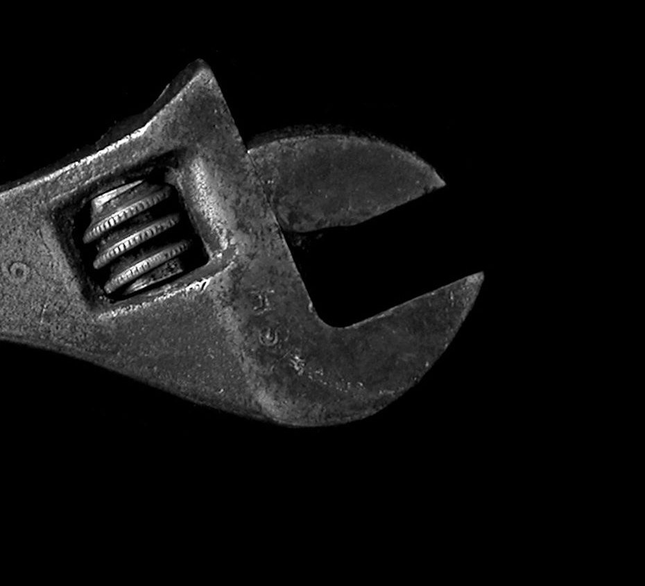 Close-up of an adjustable wrench jaw against a black background