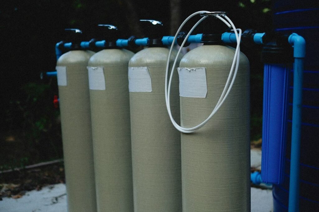 Several connected water filtration tanks and a blue filter housing.