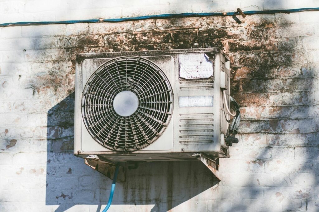 Weathered outdoor air conditioning unit mounted on an exterior wall.